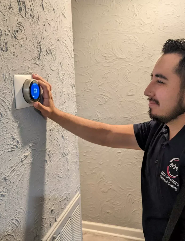 Nathaniel Segura adjusting a thermostat